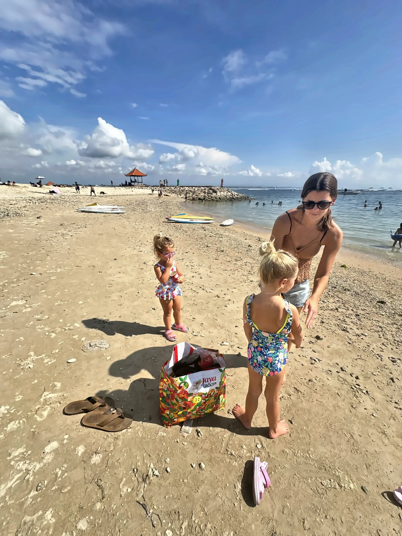 Kailah and our two daughters on a sandy beach in Bali under a blue sky