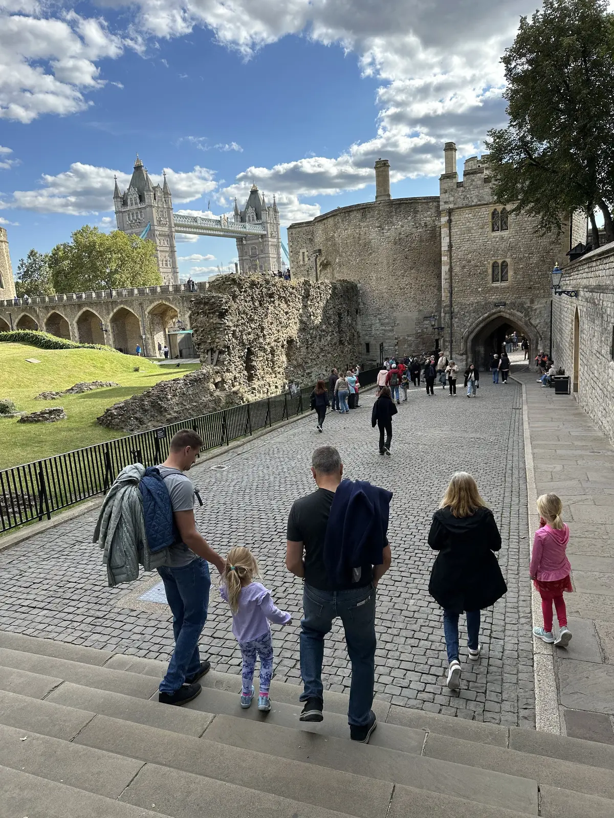 Our family walking through the Tower of London grounds, with Tower Bridge behind